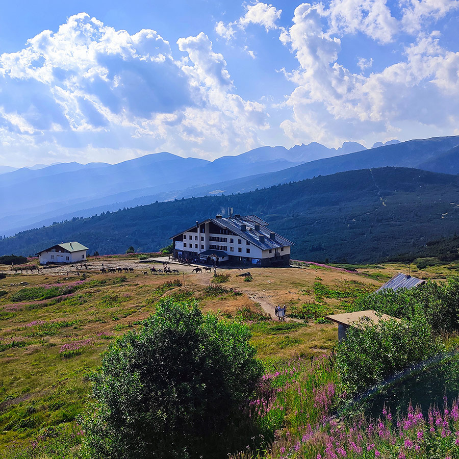 Scenic view of Rila Lakes Hut from above with mountain backdrop.