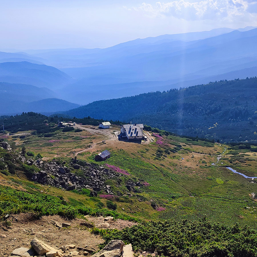 Panoramic view of Rila Lakes Hut and mountain slopes from the trail.