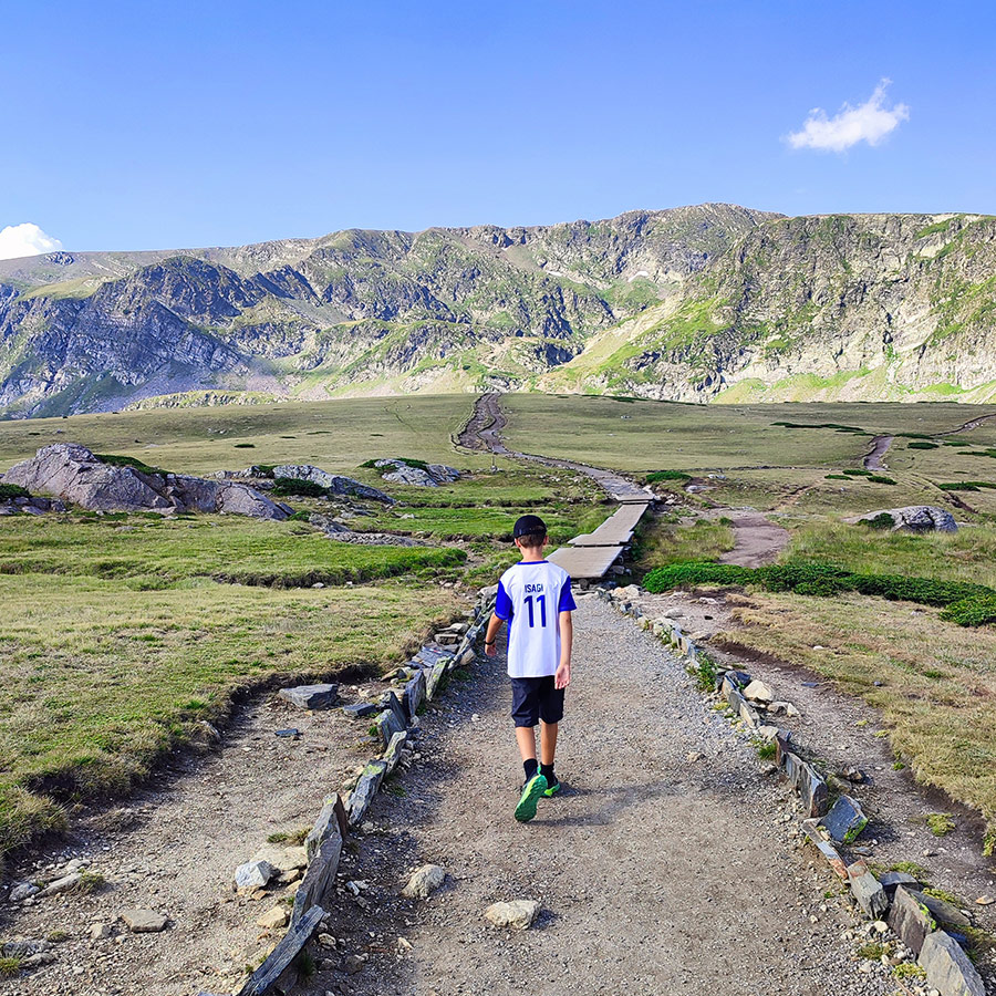 Young hiker walking on alpine path towards the Seven Rila Lakes.