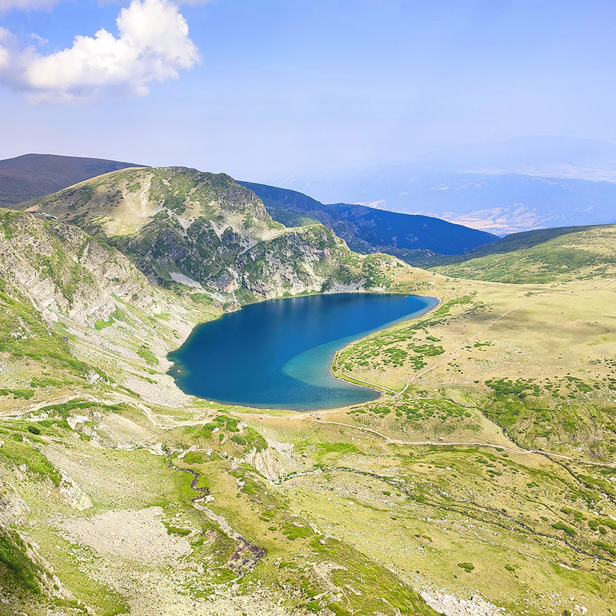 Heart-shaped view of the Seven Rila Lakes’ Kidney Lake with surrounding green ridges.