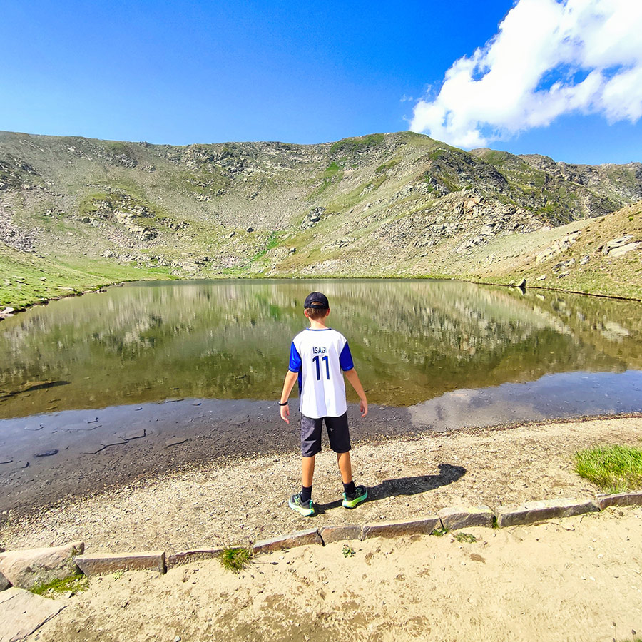 Young hiker standing at the shore of The Tear Lake in the Seven Rila Lakes.