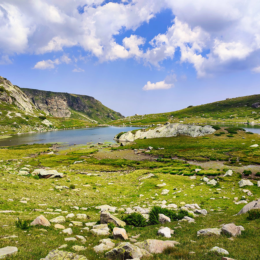 Scenic view of a glacial lake and rocky cliffs in Rila Mountain.
