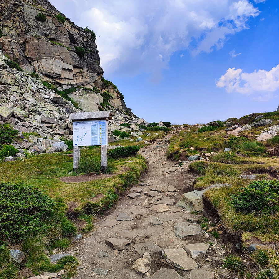 Hiking trail with a trail signboard inside Rila National Park on the way to the Seven Rila Lakes.
