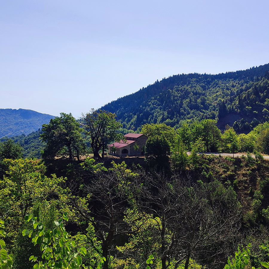 View of Anthochori village church surrounded by mountains in Agrafa, Karditsa, Greece
