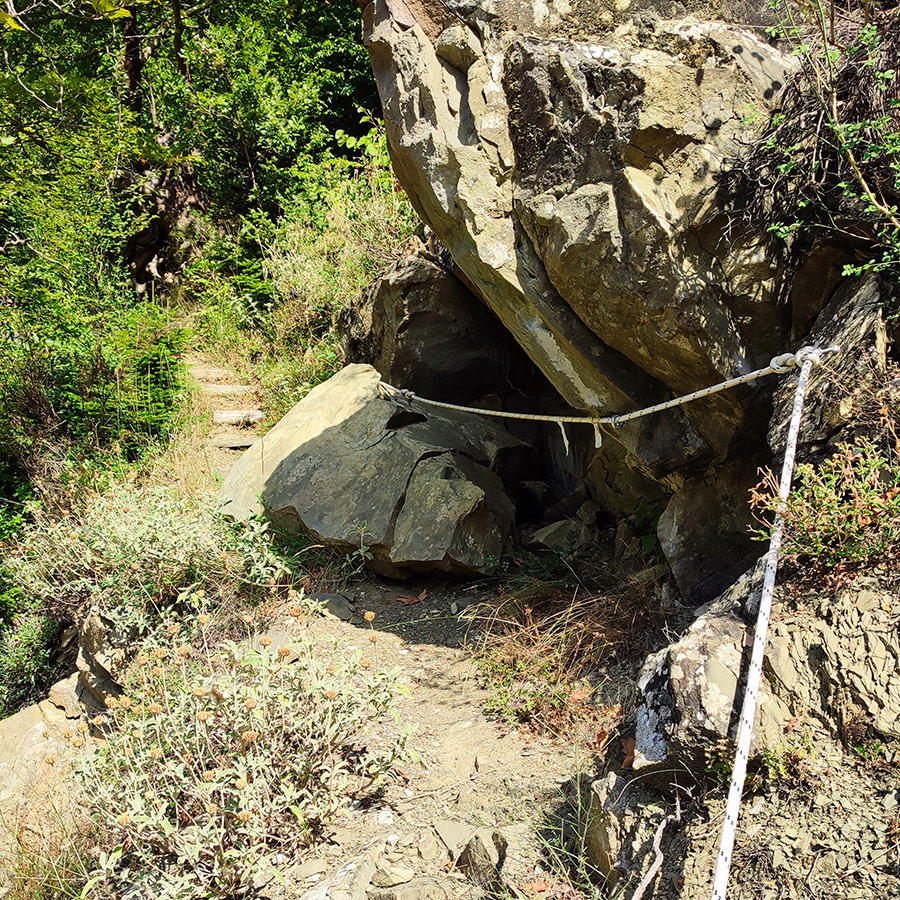 Rocky passage with safety rope on hiking trail to Anthochori Waterfall, Agrafa, Greece