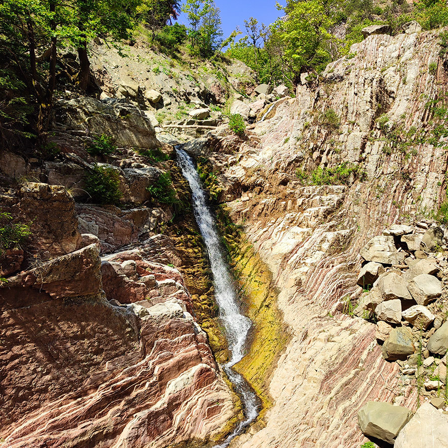 Anthochori Waterfall flowing down colorful rock formations in Agrafa, Karditsa, Greece