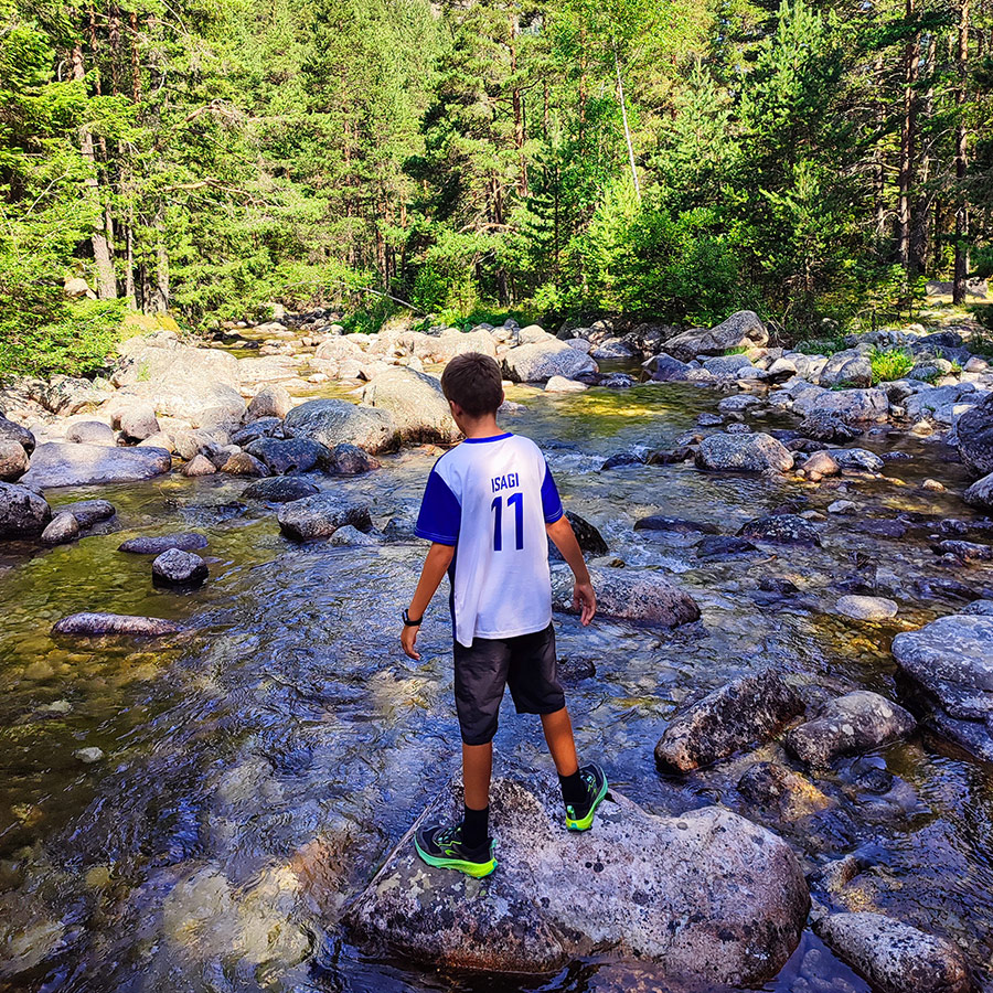 Child playing on river rocks at the Beli Iskar Eco Trail, Bulgaria