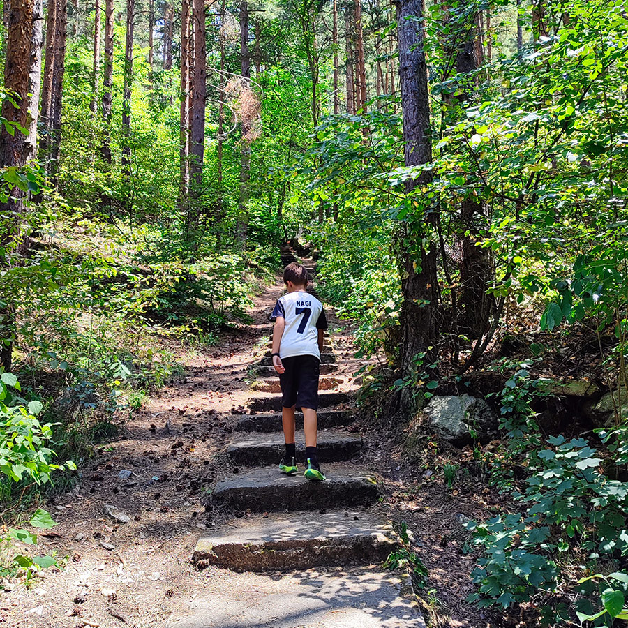 Young hiker on the forest steps of the Goritsa Waterfall trail, Rila Mountain, Bulgaria.