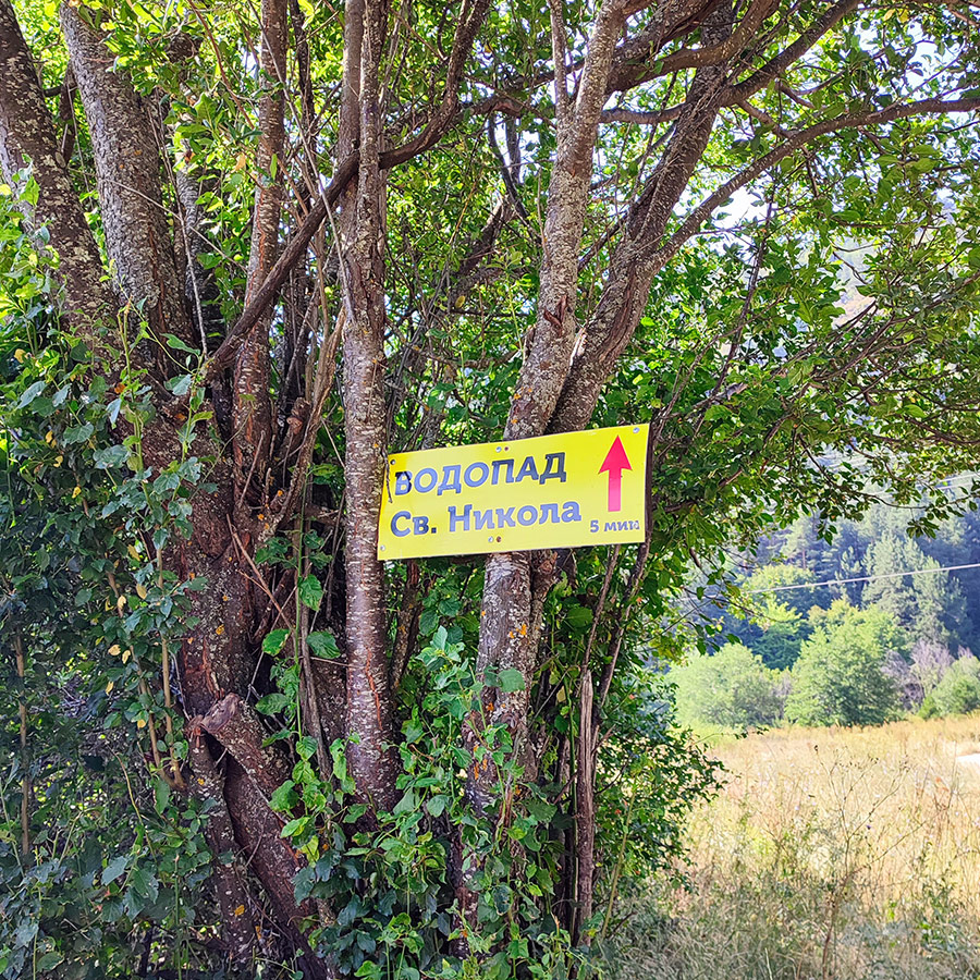 Sign on a tree showing the way to Saint Nicholas Waterfall near Bansko, Bulgaria.