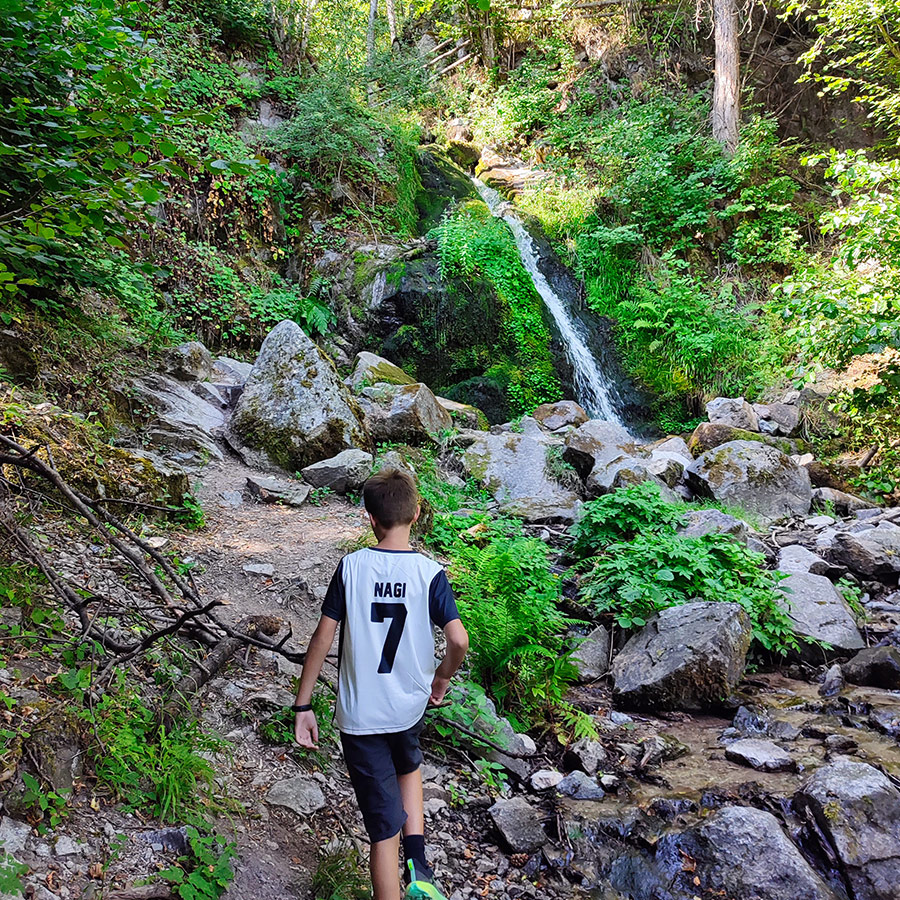 Young hiker walking along the trail towards Saint Nicholas Waterfall near Bansko, Bulgaria.