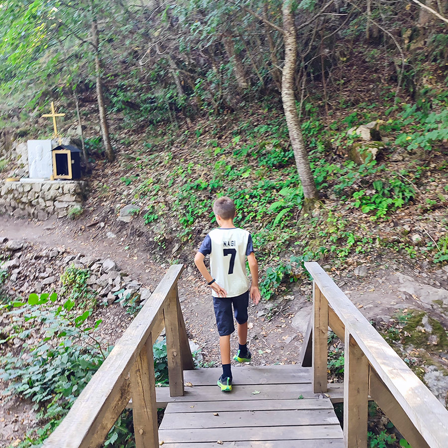 Young hiker walking along the trail towards Saint Nicholas Waterfall near Bansko, Bulgaria.