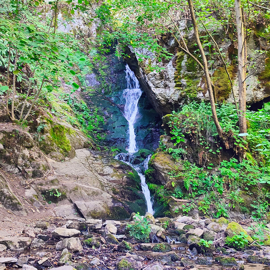 Main cascade of Saint Nicholas Waterfall surrounded by mossy cliffs near Bansko, Bulgaria.