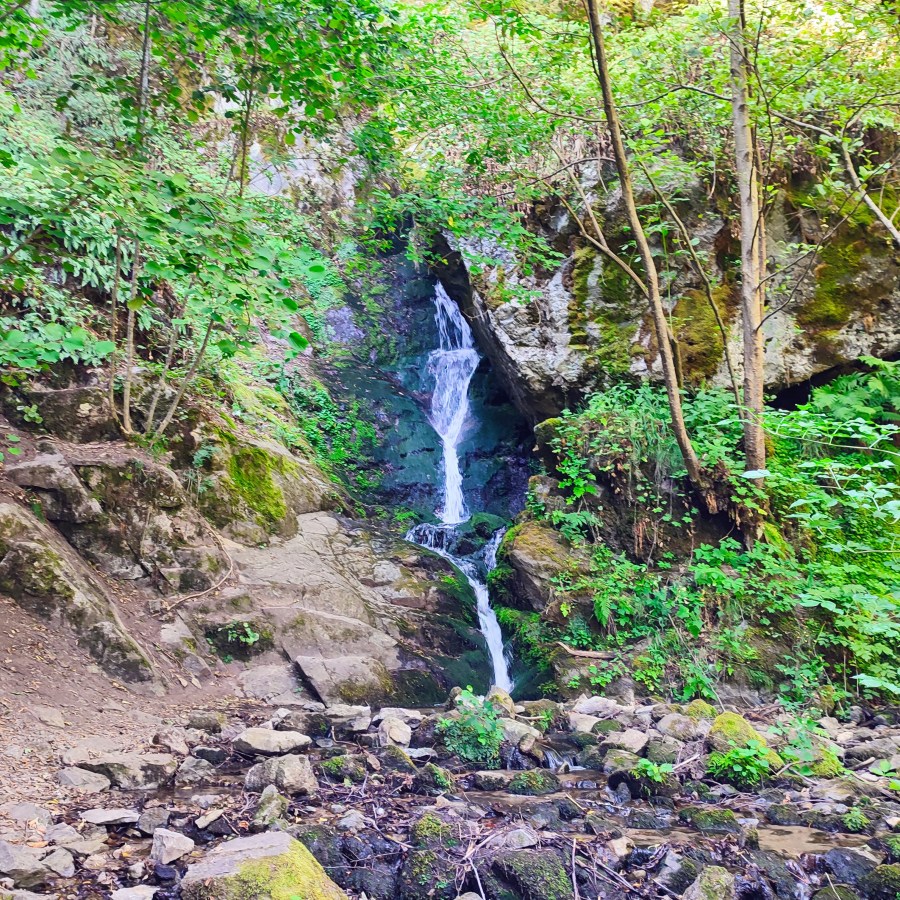Main cascade of Saint Nicholas Waterfall surrounded by mossy cliffs near Bansko, Bulgaria.