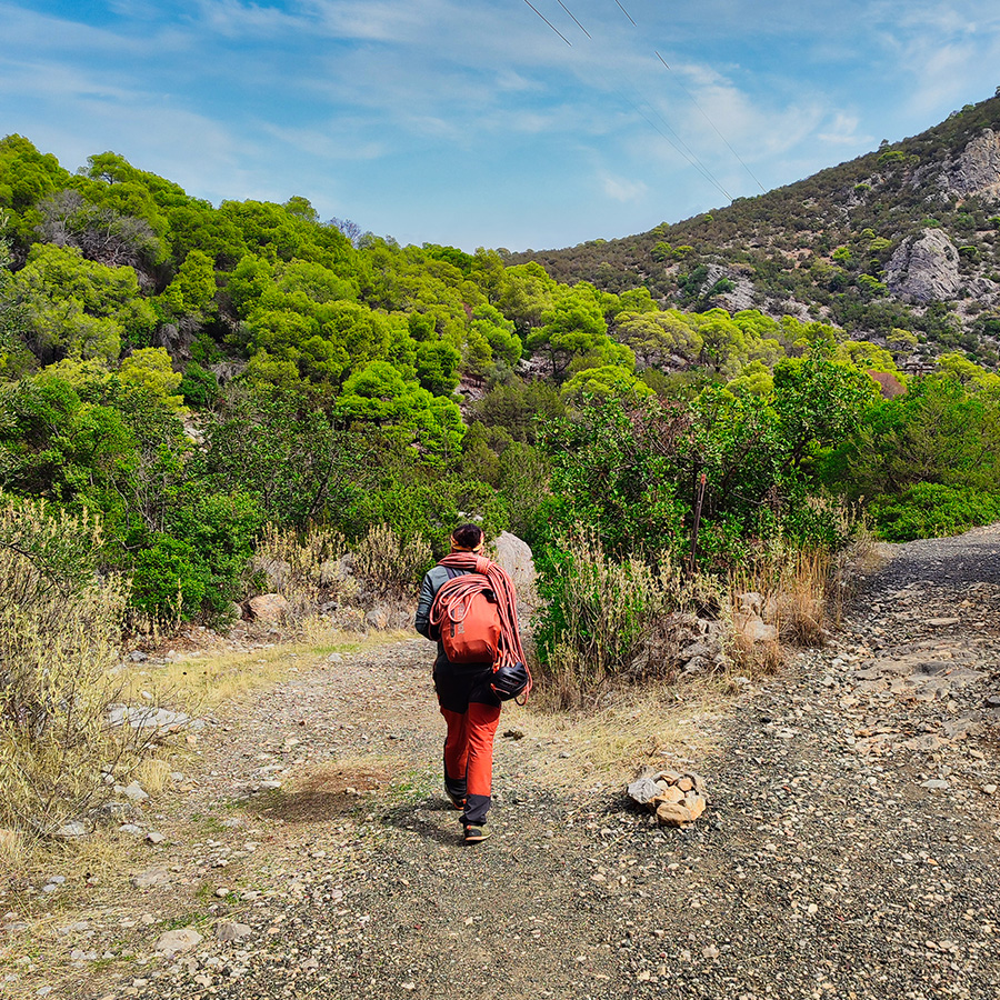Climber approaching Katafyki Gorge with gear and rope to access Pleiades Crag and the Asterope multi-pitch route.
