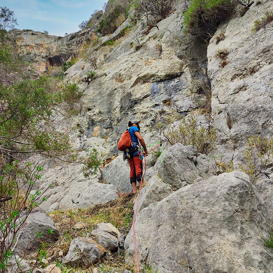 Climber standing at belay stance on the first pitch of Asterope multi-pitch route at Pleiades Crag.