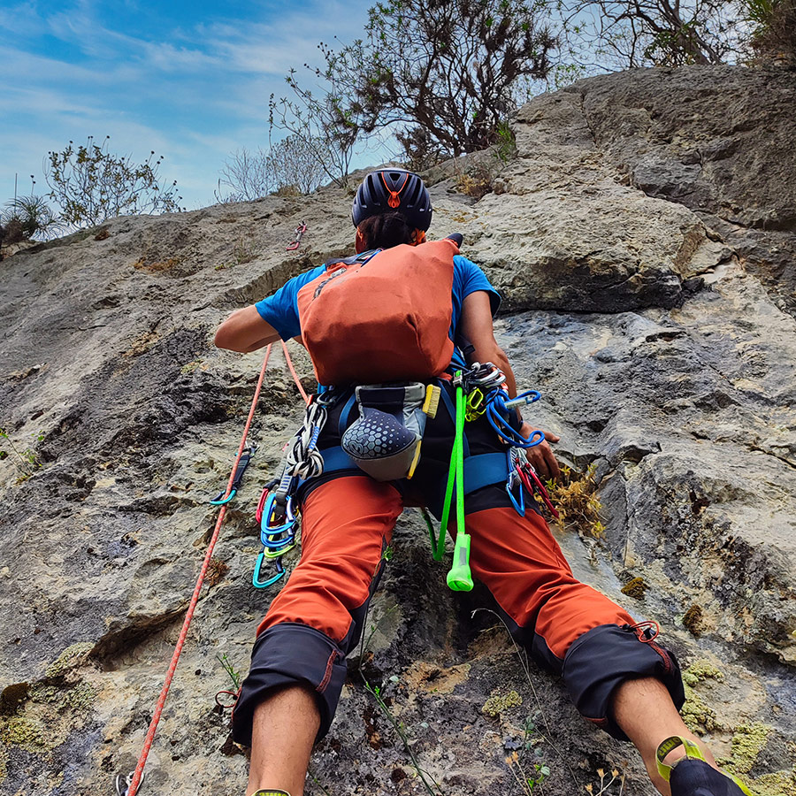 Lead climber starting the second pitch of Asterope route on solid limestone wall.