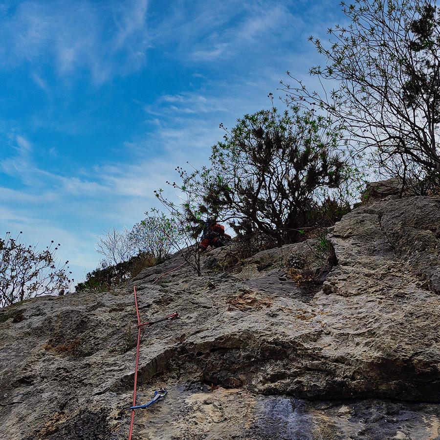 Climber reaching the belay of Asterope’s second pitch with rope extended below.