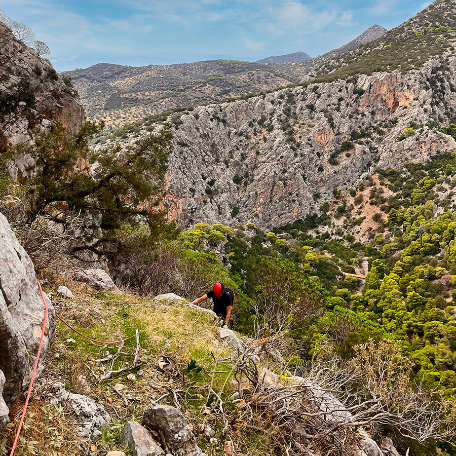 Second climber approaching belay ledge on Asterope route with Katafyki Gorge backdrop.