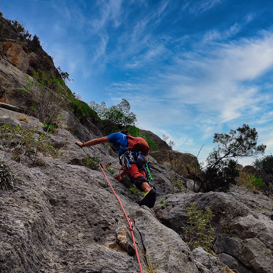 Climber progressing through exposed middle pitch of Asterope route, Ermioni.