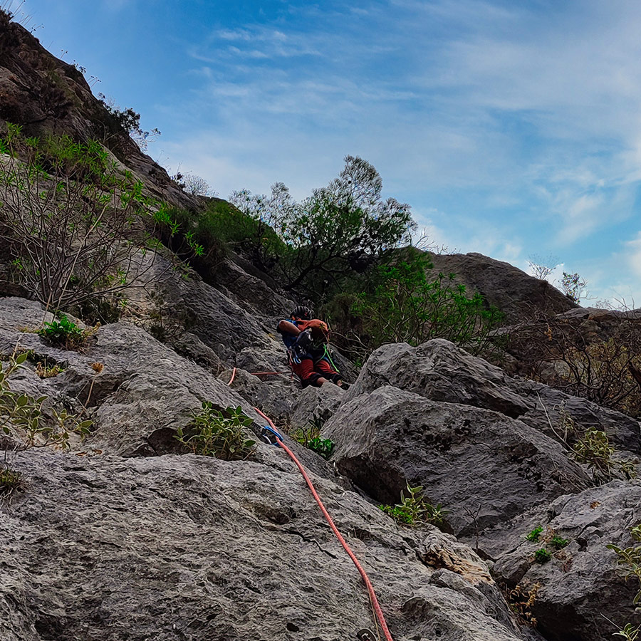 Climber tackling the crux sequence of Asterope multi-pitch climb on Pleiades Crag.