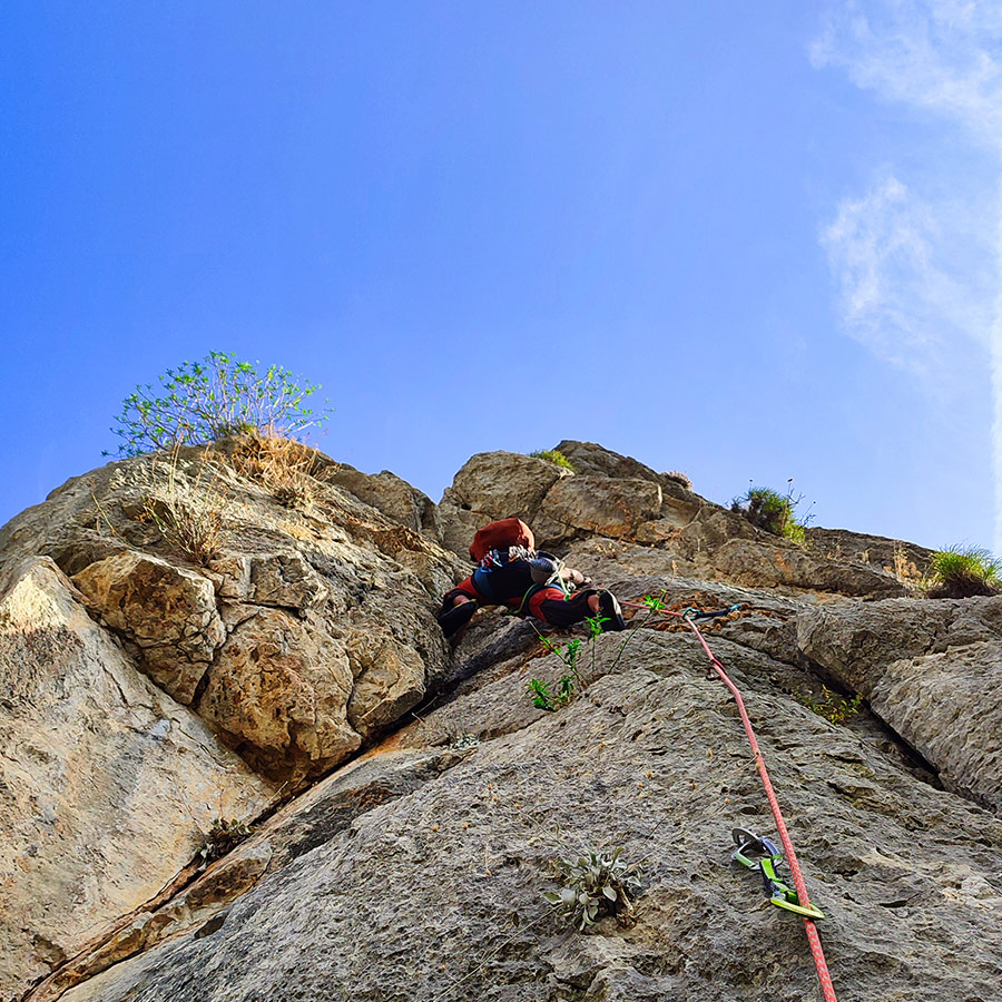 Lead climber finishing the last moves of Asterope multi-pitch climb, Pleiades Crag.