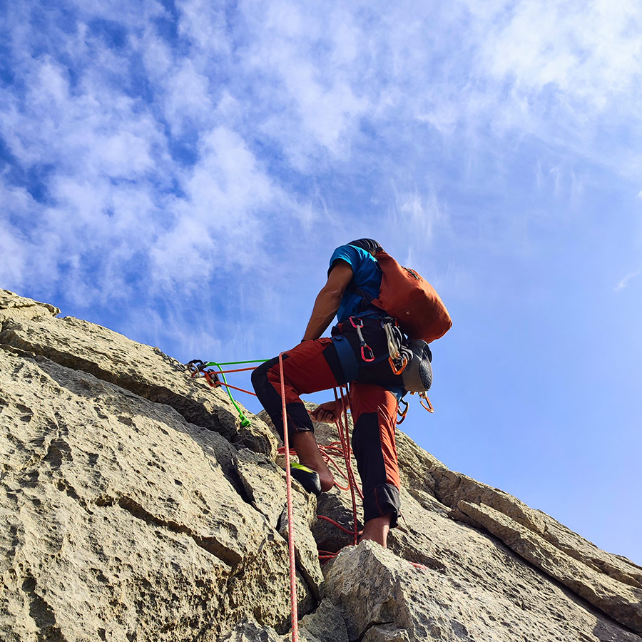 Climber securing final belay anchor on summit of Pleiades Crag, Ermioni.