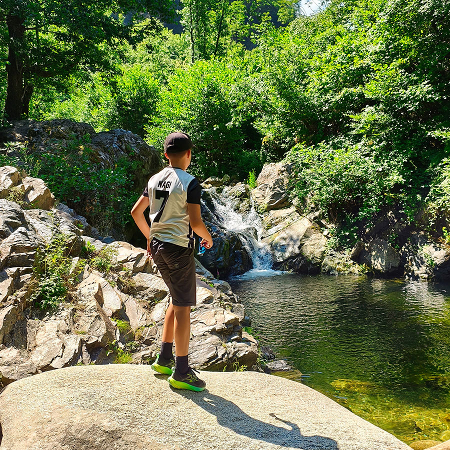 Young hiker overlooking Kapejnci Waterfall and natural pool in North Macedonia