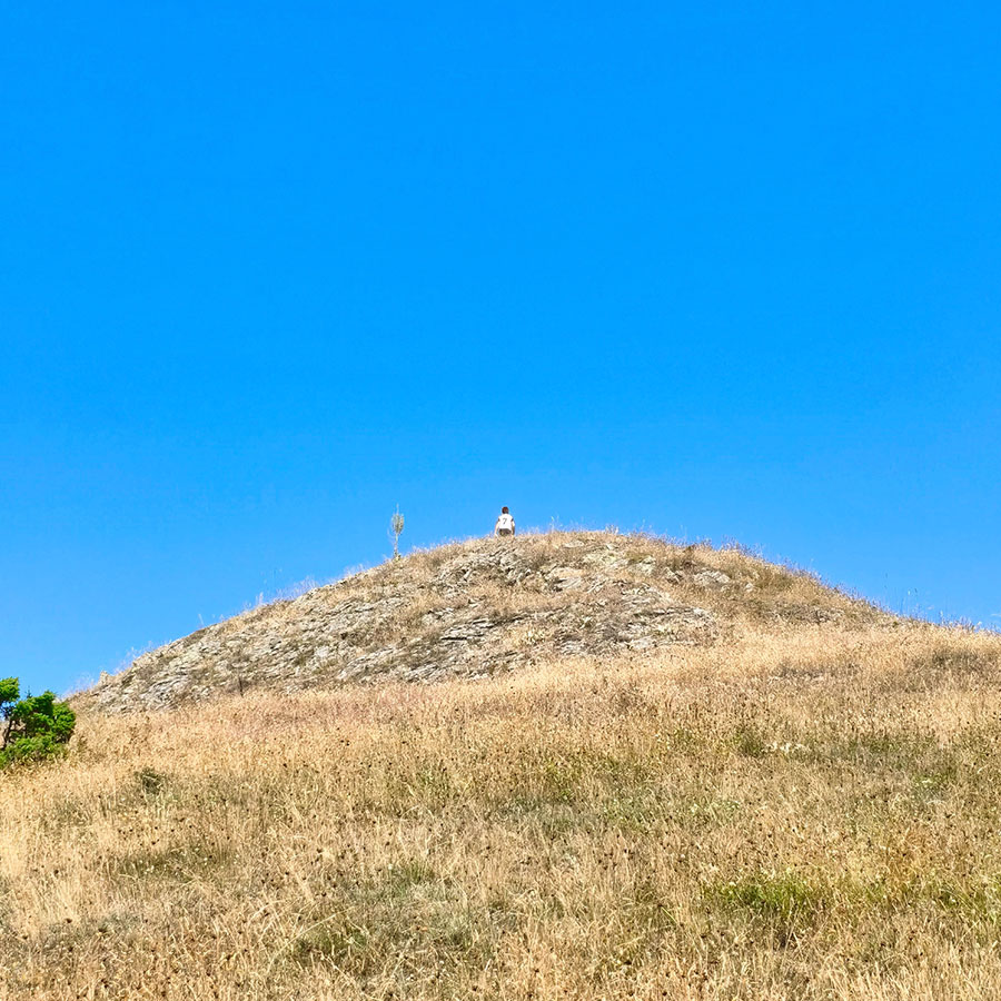 Hiker reaching the summit ridge of Voulgara Peak at 1,654 meters in Agrafa.