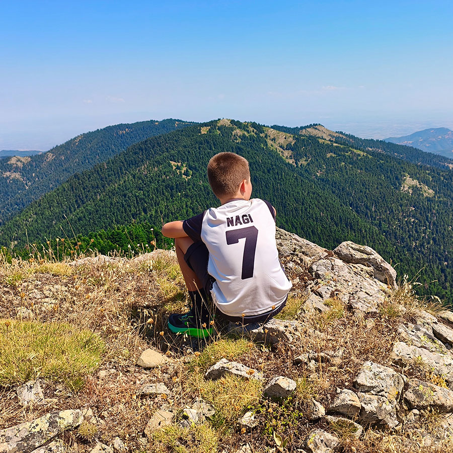 Hiker enjoying panoramic views from Voulgara Peak in the Agrafa Mountains, Greece.